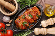 Delicious stuffed cabbage rolls cooked with tomato sauce and ingredients on wooden table, flat lay