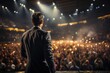 © Trinette Reed - Businessman speaking on stage to a large crowd in an auditorium