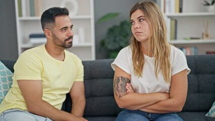 Canvas Print - Man and woman couple sitting on sofa with problems reconciling at home