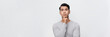 © makistock - Happy smiling young handsome Asian man face with hand touching chin isolated on white banner