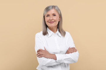 Portrait of beautiful senior woman on beige background