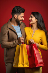 Wall Mural - Young indian couple holding shopping bags and giving happy expression