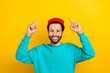 © deagreez - Portrait of cool cheerful man beaming smile indicate fingers up above empty space offer isolated on yellow color background