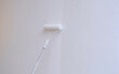 © Prapat - Long handle Roller Brush Painting White color on cement house wall, Home renovate and improvement concept