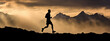 Trail runner nature landscape running man silhouette on mountains background in cold weather with clouds at sunset. Amazing scenic view of peaks in altitude.