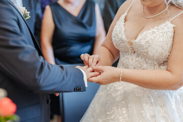 Wall Mural - Hands of a bride and groom exchanging rings during the wedding ceremony