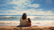 Mother And Daughter Sit On The Beach And Watch The Waves
