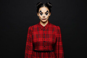 Wall Mural - Young serious cool woman with Halloween makeup face art mask wearing clown costume red dress looking camera isolated on plain solid black wall background studio portrait. Scary holiday party concept.