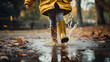 Joyful Child in Rubber Boots Jumping in Rain Puddle