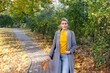© orlio - Middle age trendy woman in gray coat and jeans walking in autumn park