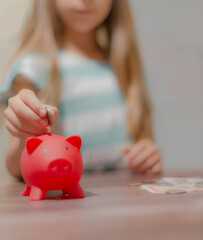 Wall Mural - Hand putting coin to piggy bank, saving money concept