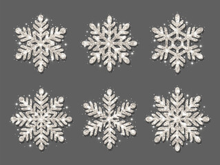 Set of snowflakes. Silver glitter texture. Christmas decoration. Shining silver snowflakes on a gray background.