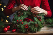 © Maryna - Christmas wreath making tutorial. Woman displaying her ornate holiday wreath.