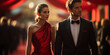 Portrait of beautiful girl in red dress and handsome man in black suit posing on red carpet