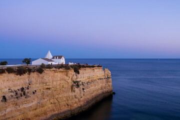 Wall Mural - View to the big cliff and the Chapel of Our Lady of the Rock (Igreja de Nossa Senhora da Rocha). Dreamy tranquil sunset scenery.  Porches, Algarve, Portugal