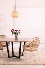 Chairs And Table With Vase Of Red Rose Flowers In Dining Room. Stylish Interior
