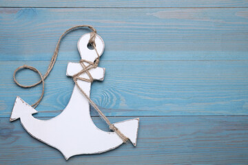 Sticker - White anchor with hemp rope on light blue wooden table, top view. Space for text