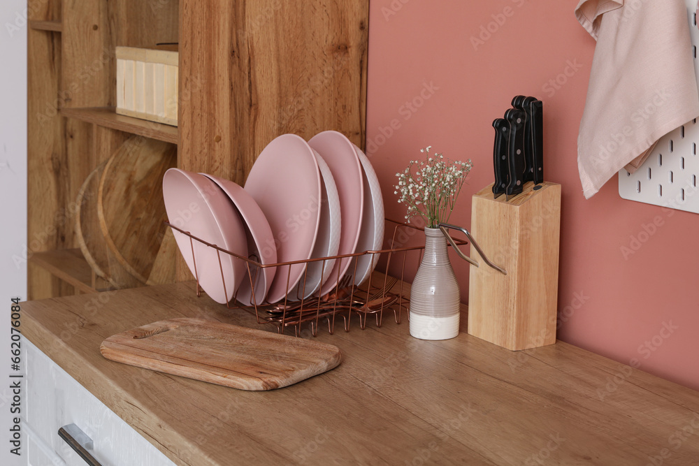 Wooden kitchen counter with plate rack, cutting boards and utensils