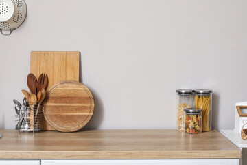 Wall Mural - Wooden kitchen counter with cutting boards, utensils and jars