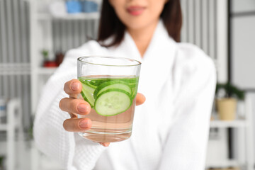 Sticker - Young Asian woman with glass of cucumber water at home, closeup