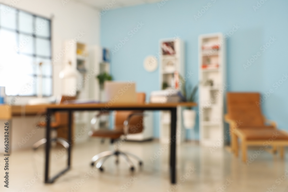 Blurred view of stylish office with workplaces and shelf units