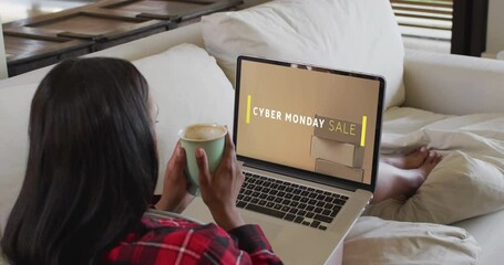 Sticker - Biracial woman using laptop at home online shopping on cyber monday sale day, slow motion