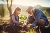 Fototapeta Paryż - Héritage familial : Grand-père et petite-fille plantent un arbre ensemble