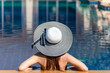 © freebird7977 - Summer time and Vacations. Women lifestyle with fashion big hat relaxing and happy in luxury swimming pool outdoor, summer day at the beach resort in the hotel. Summer Concept