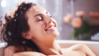 Young brunette woman smiling and relaxing in bath