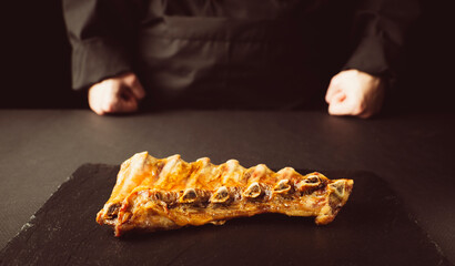 Wall Mural - pork ribs with spices on a black background. the concept of recipes and restaurant menus