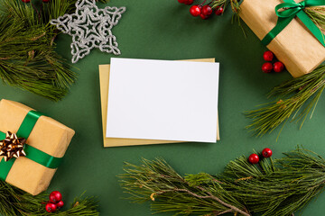 Poster - Christmas decorations and white card with copy space on green background