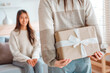© oatawa - Surprise woman is giving her young girl friend a present at home, New year gift.