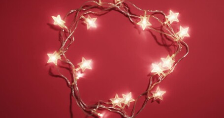 Canvas Print - Video of fairy lights christmas decorations with copy space on red background