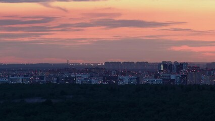 Wall Mural - Panorama of the evening city with the light coming on in the windows of houses, timelapse