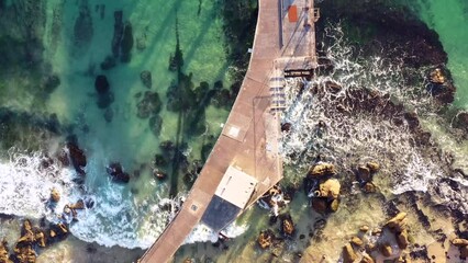 Poster - Historic timber jetty in aerial vertical panorama to Pacific ocean horizon as 4k.
