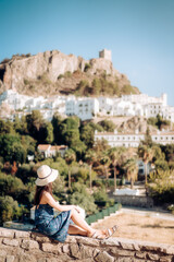 Wall Mural - Woman in travel, Asian woman in blue dress looking at the old city, Zahara de la Sierra in Cadiz, Spain