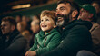 Irish father and son in stands, filled with enthusiastic supporters of rugby or football team wearing green clothes to support national sports team