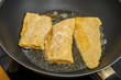 Kawałki ryby smażone na rozgrzanej patelni z olejem rzepakowym