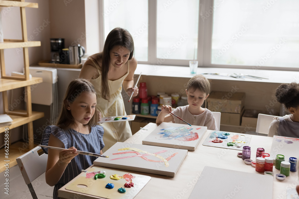 Group of cute little children engaged in painting class in art-studio ...