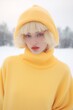 © Glittering Humanity - A stunning woman braves the cold in a bright yellow sweater and bonnet, exuding fashion and confidence as she poses in the winter snow