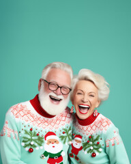 An older couple donning festive sweaters adorned with christmas motifs smile and laugh happily, their glasses glinting in the indoor light as they stand against a wall, joy  of the holiday season