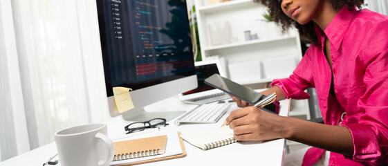 Young working African woman creating coding website developer, thinking data information designer at home office, focusing on laptop Concept of analytical data center in java project job. Tastemaker.