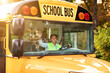 © Prostock-studio - Portrait of joyful young black female driver steering yellow school bus