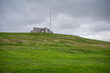 House building with radar tower on top of a hill near graveyard at Shetland island, Scotland