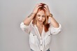 © Krakenimages.com - Young caucasian woman standing over isolated background suffering from headache desperate and stressed because pain and migraine. hands on head.