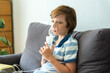 © irena_geo - Home treatment. The boy makes inhalation with a nebulizer inhaling medicines into his lungs. Self-treatment of the respiratory tract with inhalation. Little boy using nebulizer during inhaling therapy