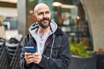 Poster - Young bald man smiling confident using smartphone at street