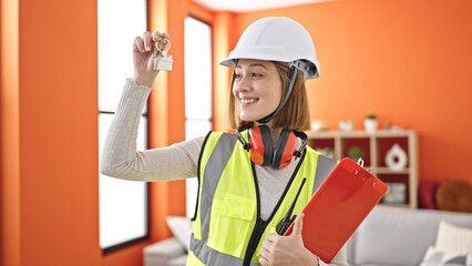 Sticker - Young blonde woman architect holding keys of new home and clipboard at home