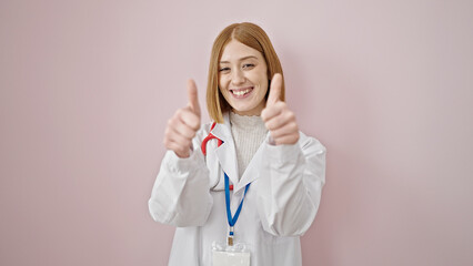 Wall Mural - Young blonde woman doctor doing thumbs up over isolated pink background