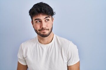 Sticker - Hispanic man with beard standing over white background smiling looking to the side and staring away thinking.